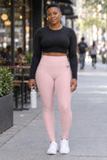 Woman wearing the Blush Pink Essential High-Waisted Yoga Leggings with the Vantacore V emblem on the hip – front view