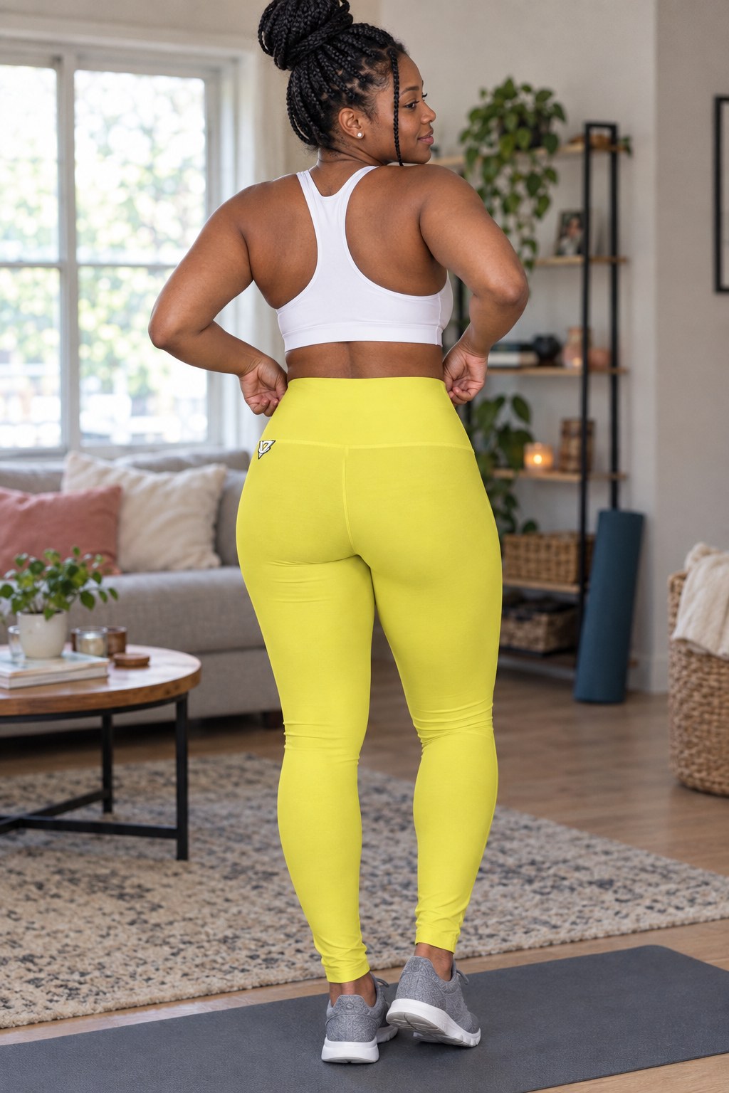 Woman wearing the Lemon Yellow Essential High-Waisted Yoga Leggings with the Vantacore V emblem on the hip – back view