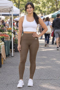 Woman wearing the Mocha Brown Essential High-Waisted Yoga Leggings with the Vantacore V emblem on the hip – front view