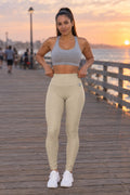 Woman wearing the Sand Beige Essential High-Waisted Yoga Leggings with the Vantacore V emblem on the hip – front view