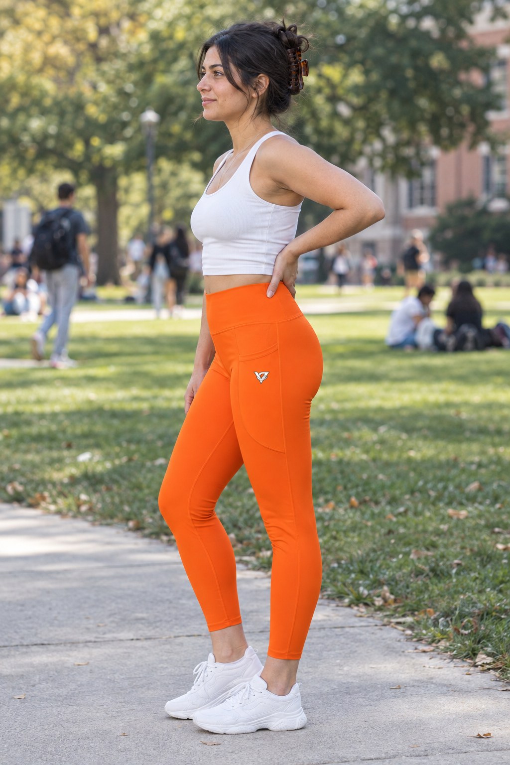 Blaze Orange Essential leggings with pockets, AI-generated fictional adult model – side view showing the side pocket and V emblem