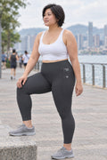 Charcoal Grey Essential leggings with pockets, AI-generated fictional adult model – front three-quarter view showing the side pocket