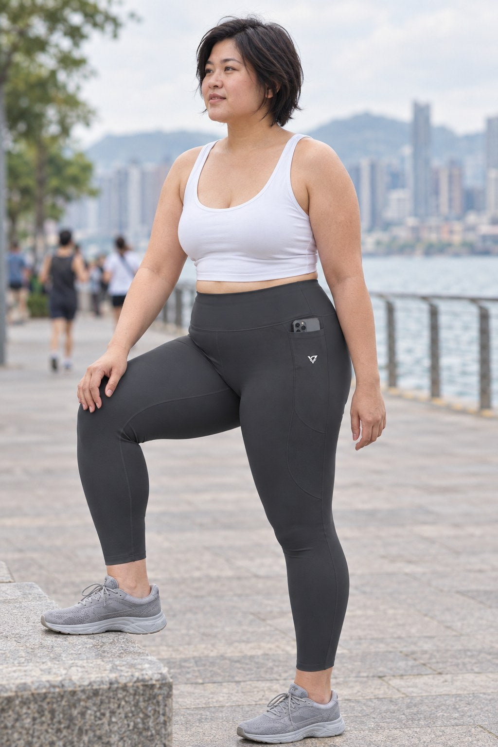 Charcoal Grey Essential leggings with pockets, AI-generated fictional adult model – front three-quarter view showing the side pocket