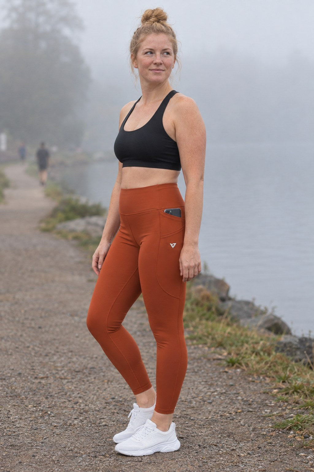 Rust Essential leggings with pockets, AI-generated fictional adult model – front three-quarter view showing the side pocket