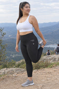 Stealth Black Essential leggings with pockets, AI-generated fictional adult model – front three-quarter view showing the side pocket