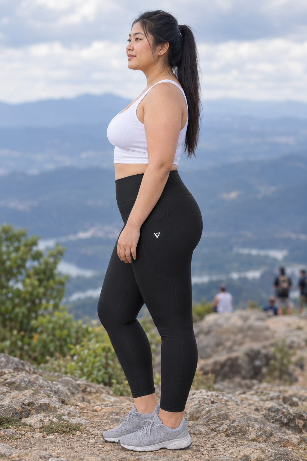 Stealth Black Essential leggings with pockets, AI-generated fictional adult model – side view showing the side pocket and V emblem