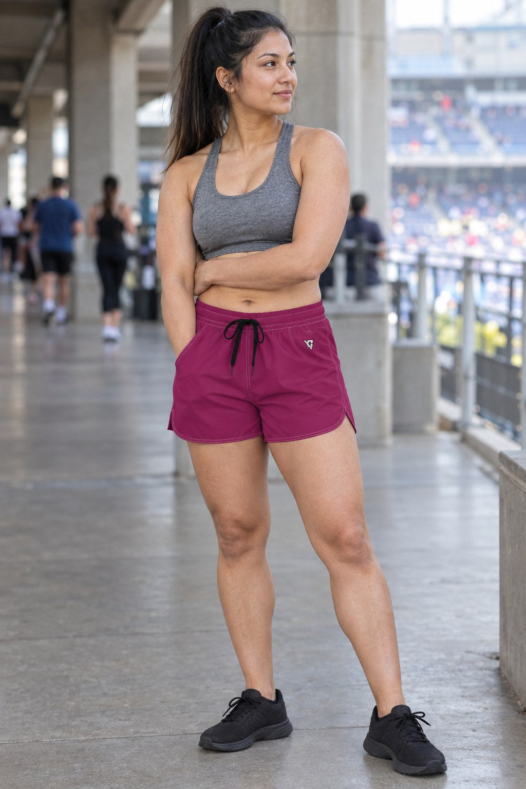 Woman wearing the Berry Essential women's athletic shorts with pockets and the Vantacore V emblem – three-quarter view showing the side pocket and V emblem