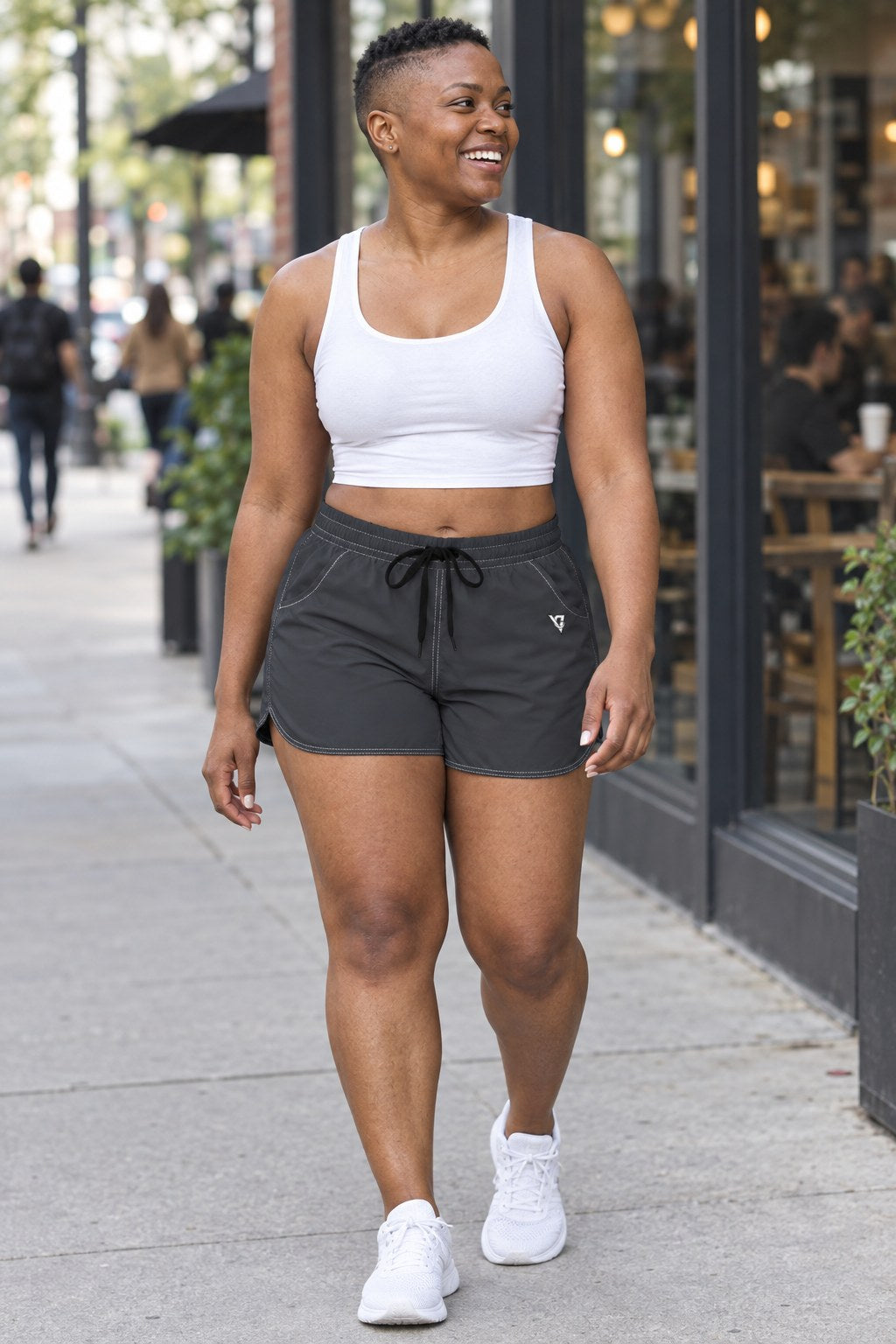 Woman wearing the Charcoal Grey Essential women's athletic shorts with pockets and the Vantacore V emblem – front view