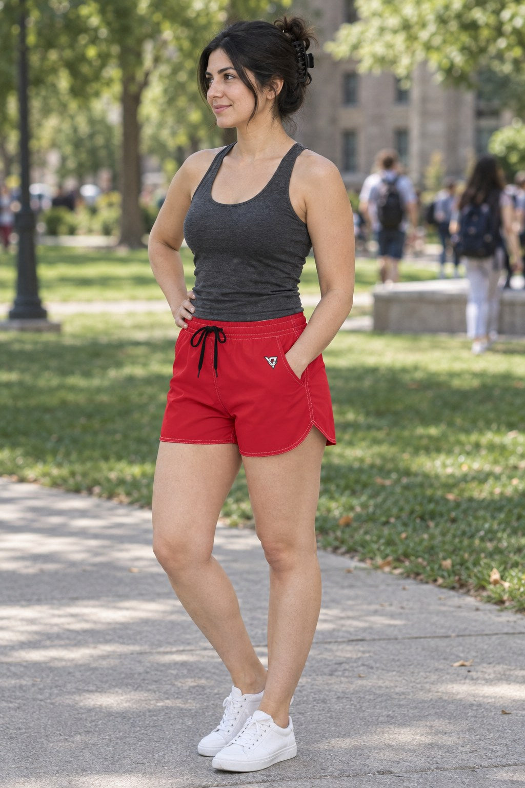 Woman wearing the Cherry Red Essential women's athletic shorts with pockets and the Vantacore V emblem – three-quarter view showing the side pocket and V emblem