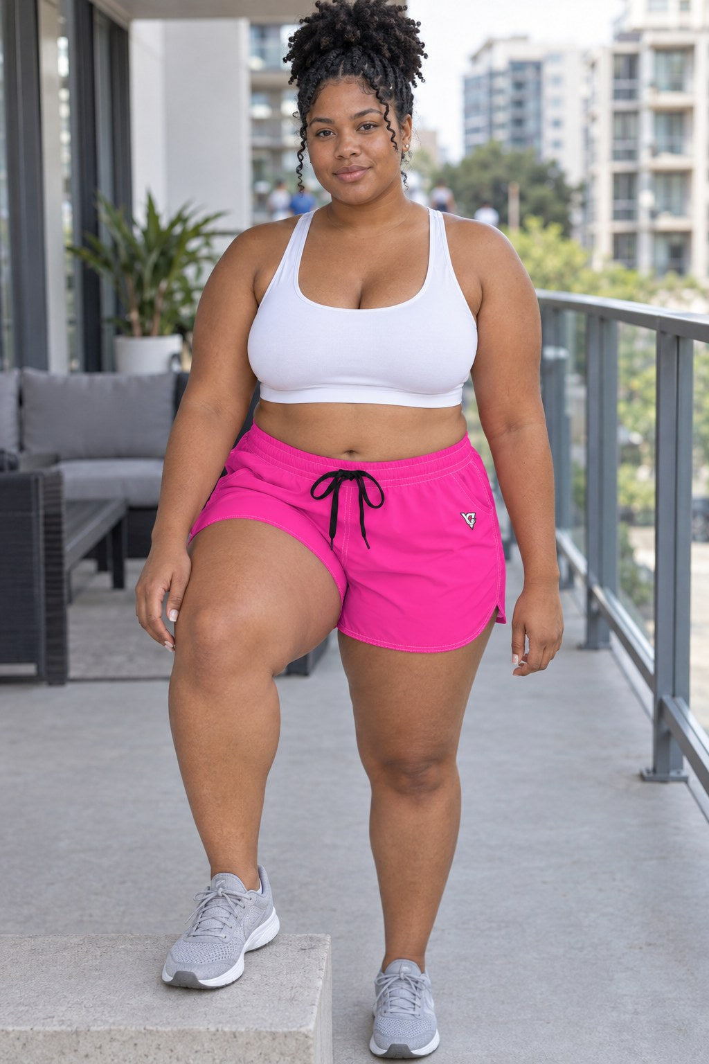Woman wearing the Electric Pink Essential women's athletic shorts with pockets and the Vantacore V emblem – front view