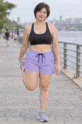 Woman wearing the Lavender Essential women's athletic shorts with pockets and the Vantacore V emblem – front view