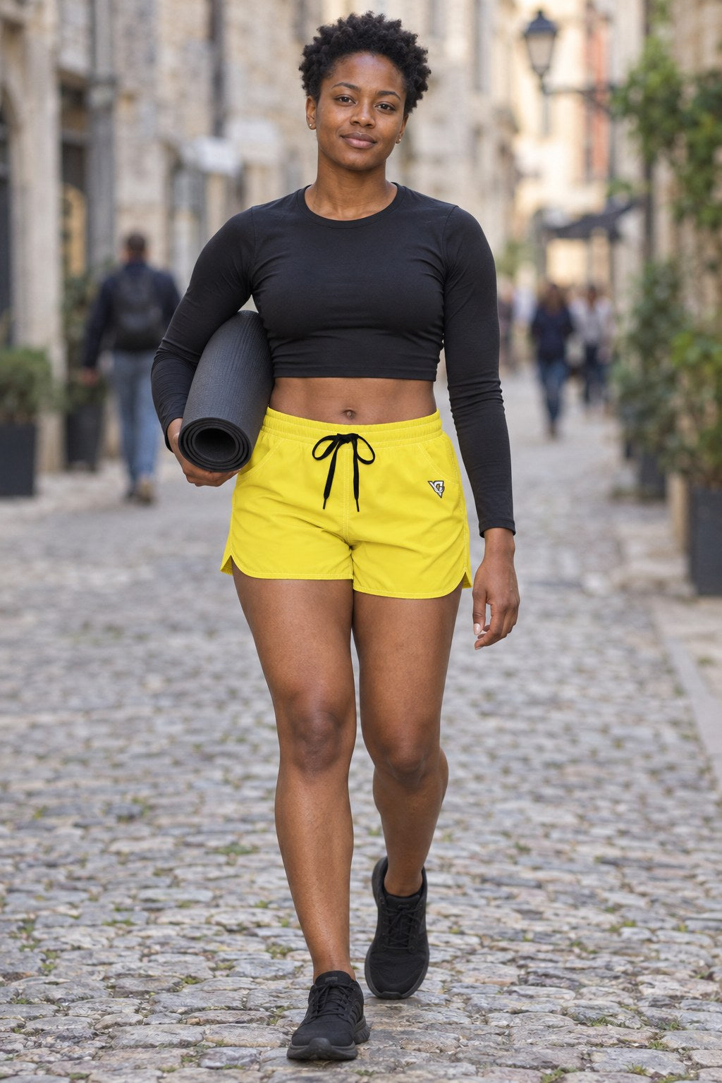 Woman wearing the Lemon Yellow Essential women's athletic shorts with pockets and the Vantacore V emblem – front view