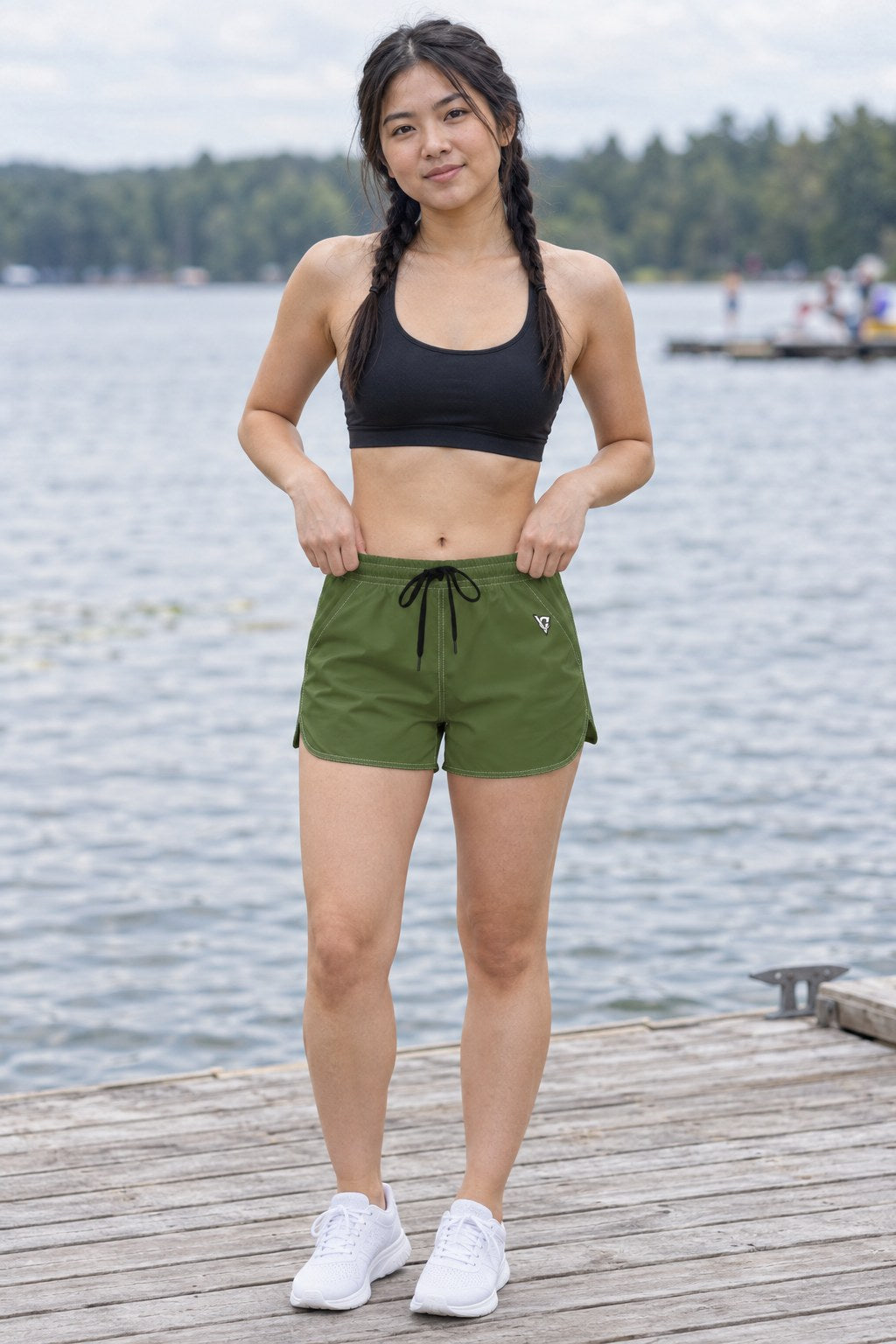 Woman wearing the Olive Green Essential women's athletic shorts with pockets and the Vantacore V emblem – front view