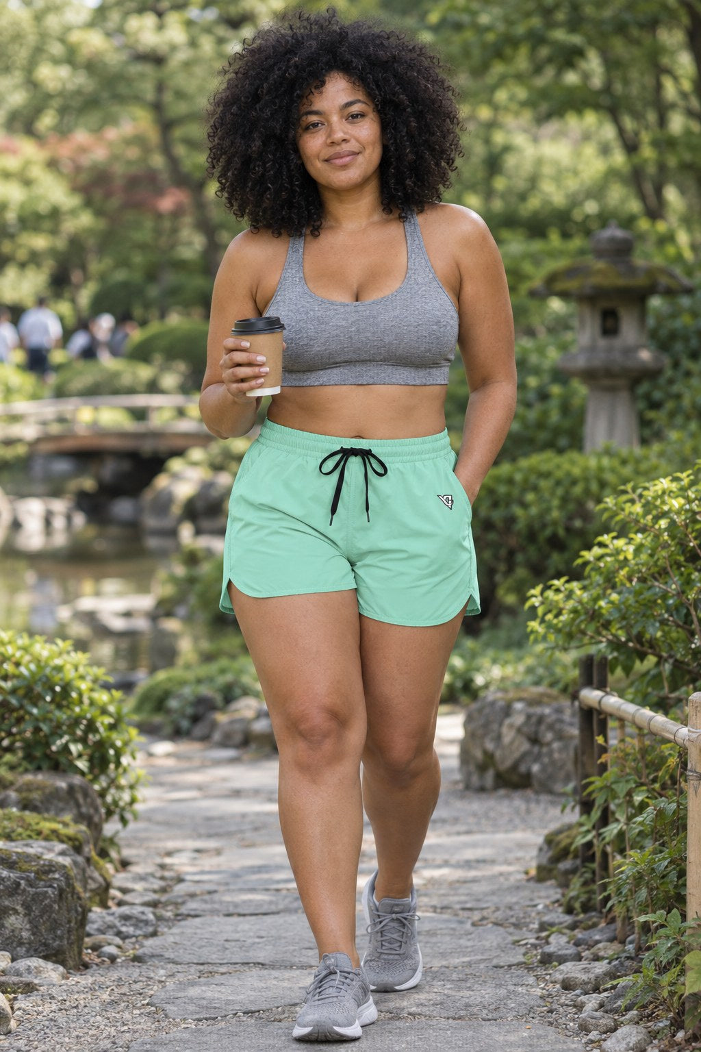 Woman wearing the Seafoam Mint Essential women's athletic shorts with pockets and the Vantacore V emblem – front view