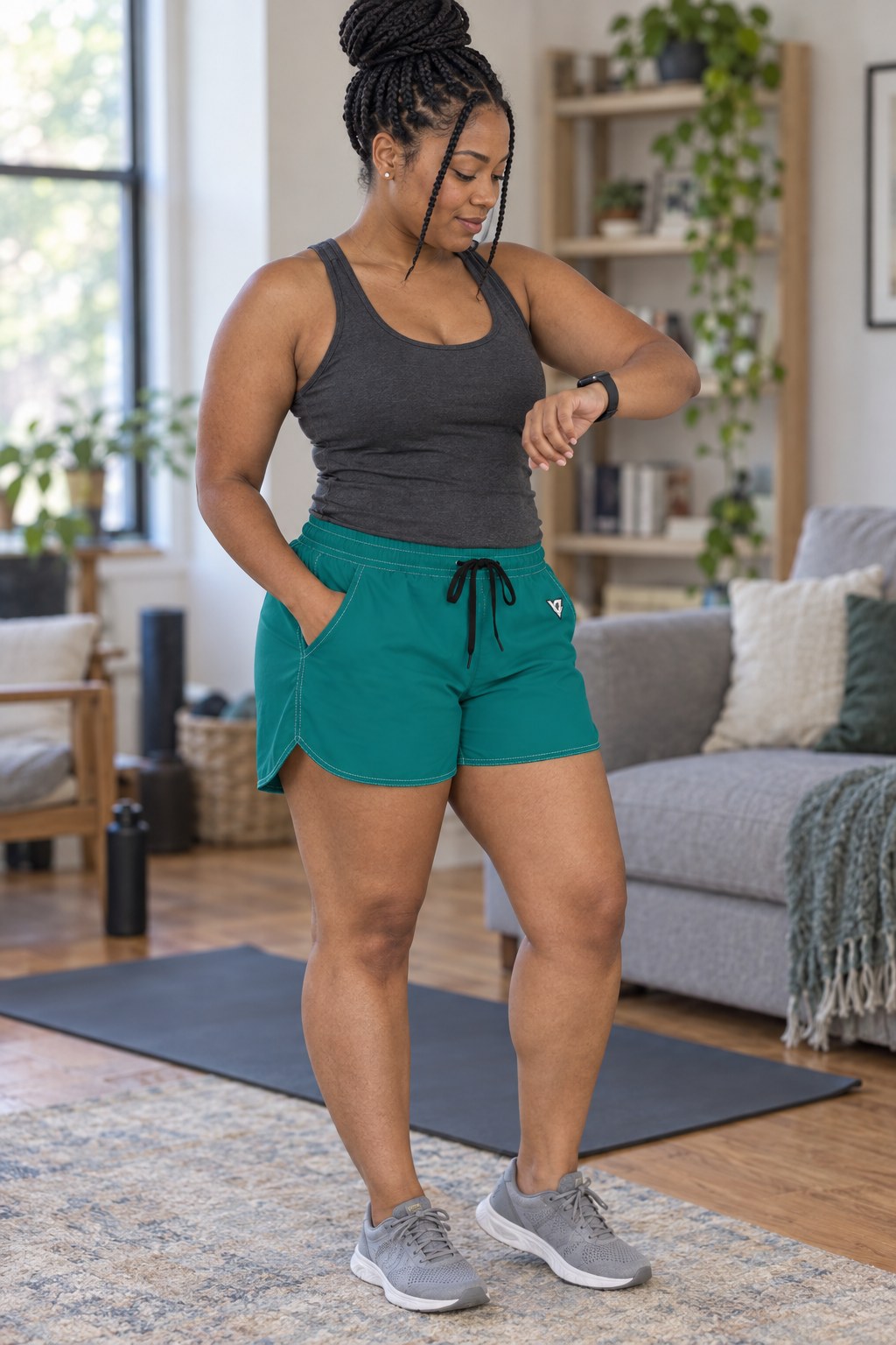 Woman wearing the Teal Essential women's athletic shorts with pockets and the Vantacore V emblem – three-quarter view showing the side pocket and V emblem