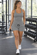 Woman wearing the Ash Gray women's full-length racerback tank and pocket shorts matching set by Vantacore Athletics