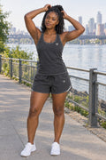 Woman wearing the Charcoal Grey Essential women's full-length racerback tank and pocket shorts matching set by Vantacore Athletics