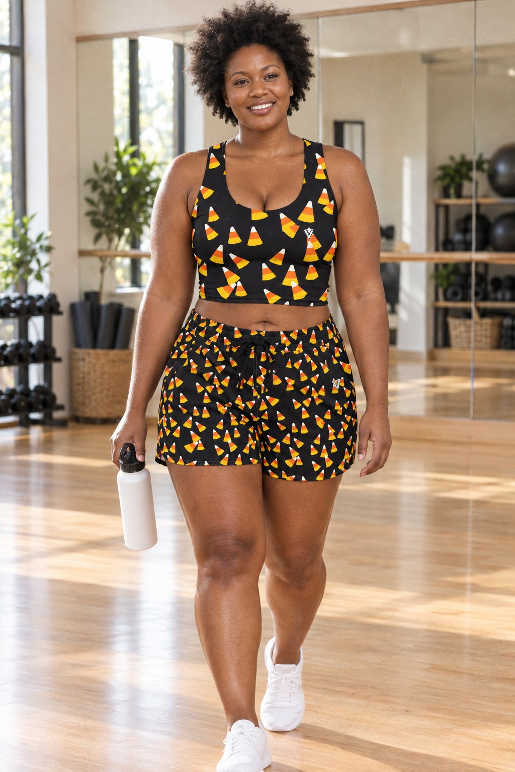 Woman wearing the Halloween Midnight Pumpkin Candy Corn Toss women's crop tank and pocket shorts matching set by Vantacore Athletics