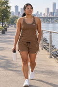 Woman wearing the Mocha Brown Essential women's matching full-length racerback tank by Vantacore Athletics, shown with the matching pocket shorts (sold separately)