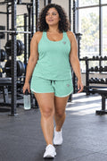 Woman wearing the Seafoam Mint Essential women's full-length racerback tank and pocket shorts matching set by Vantacore Athletics
