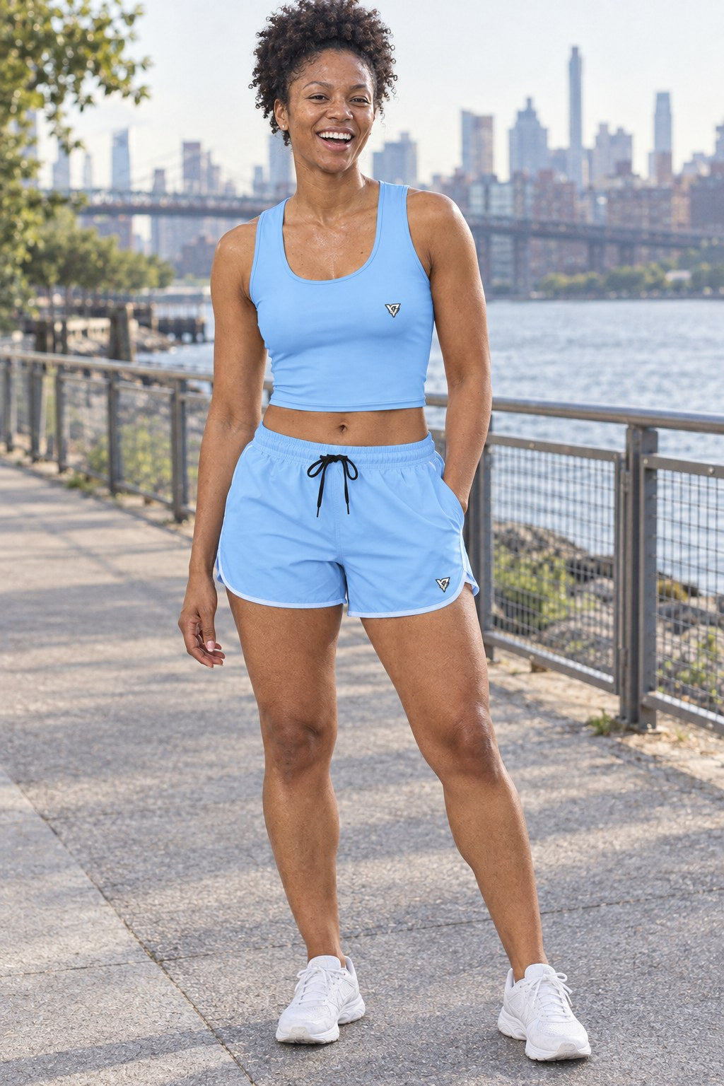 Woman wearing the Sky Blue women's matching crop tank by Vantacore Athletics, shown with the matching pocket shorts (sold separately)