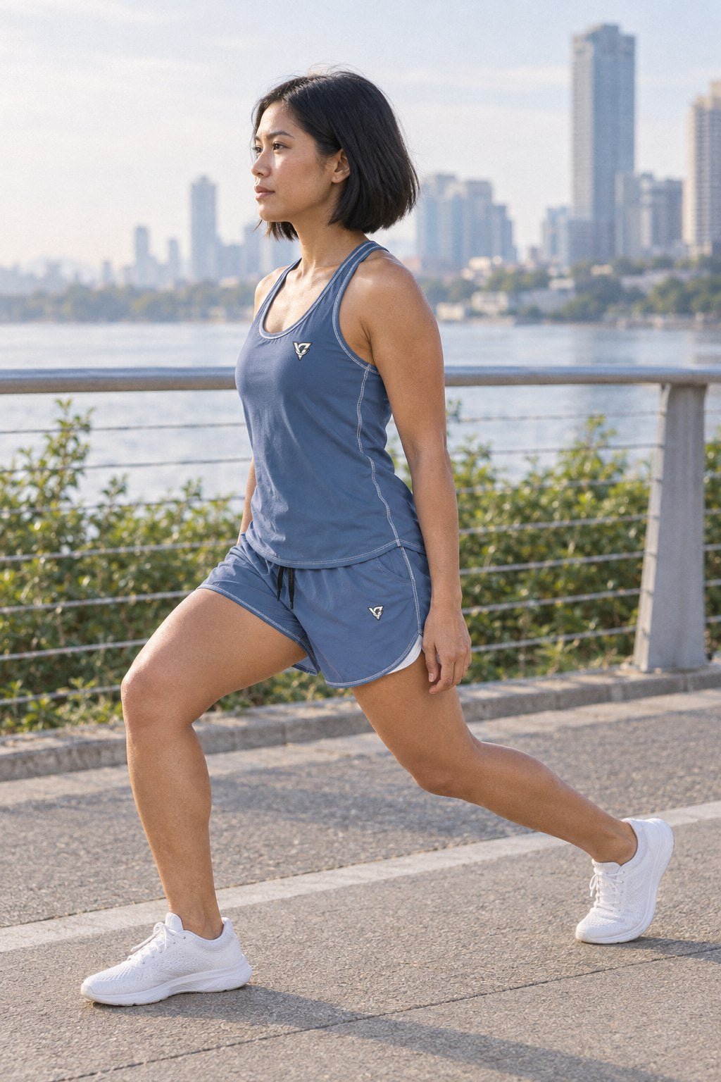 Woman wearing the Slate Blue Essential women's full-length racerback tank and pocket shorts matching set by Vantacore Athletics, side view