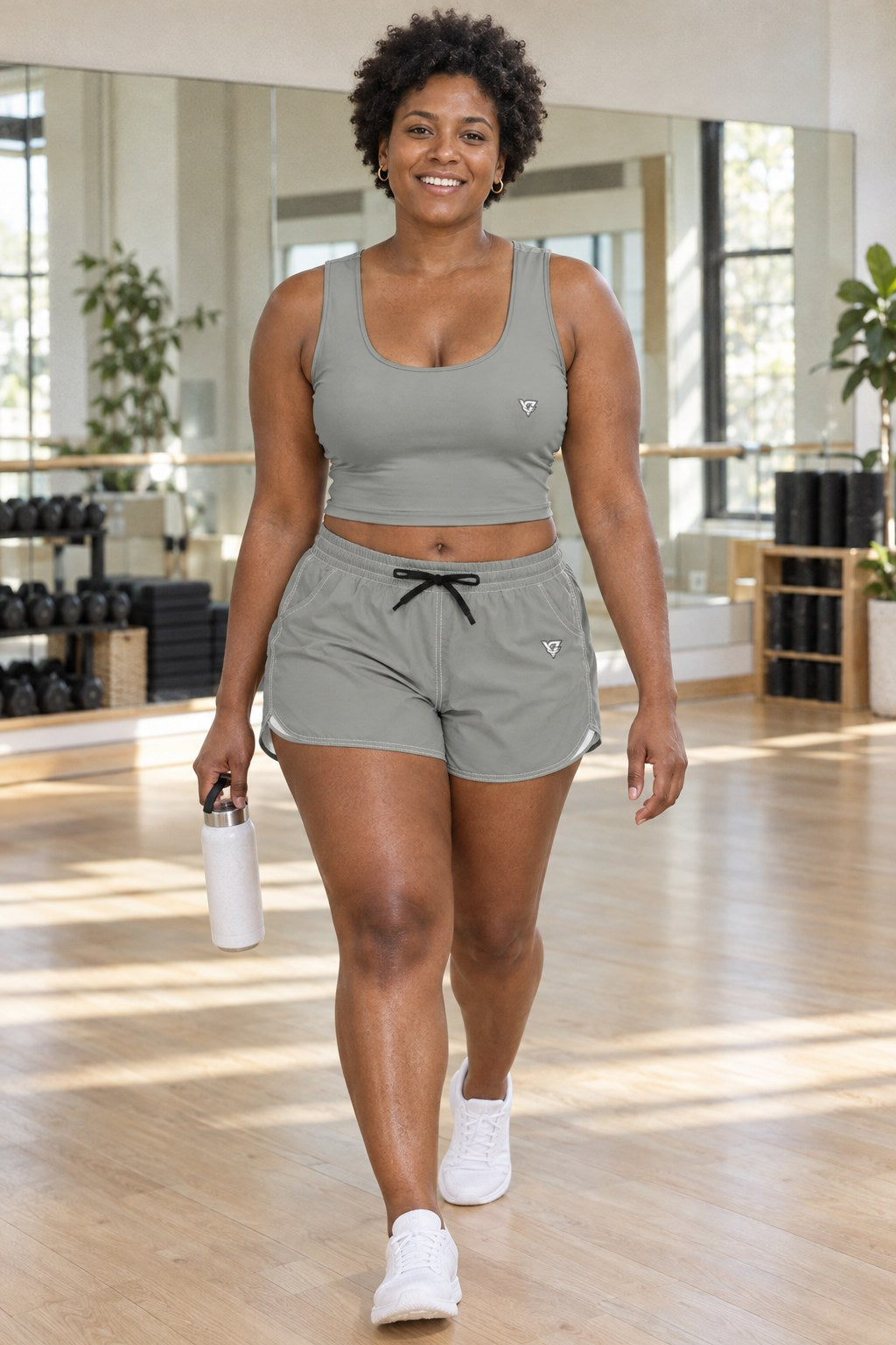 Woman wearing the Stone Grey Essential women's matching crop tank by Vantacore Athletics, shown with the matching pocket shorts (sold separately)