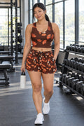Woman wearing the Terracotta Falling Leaves women's crop tank and pocket shorts matching set by Vantacore Athletics