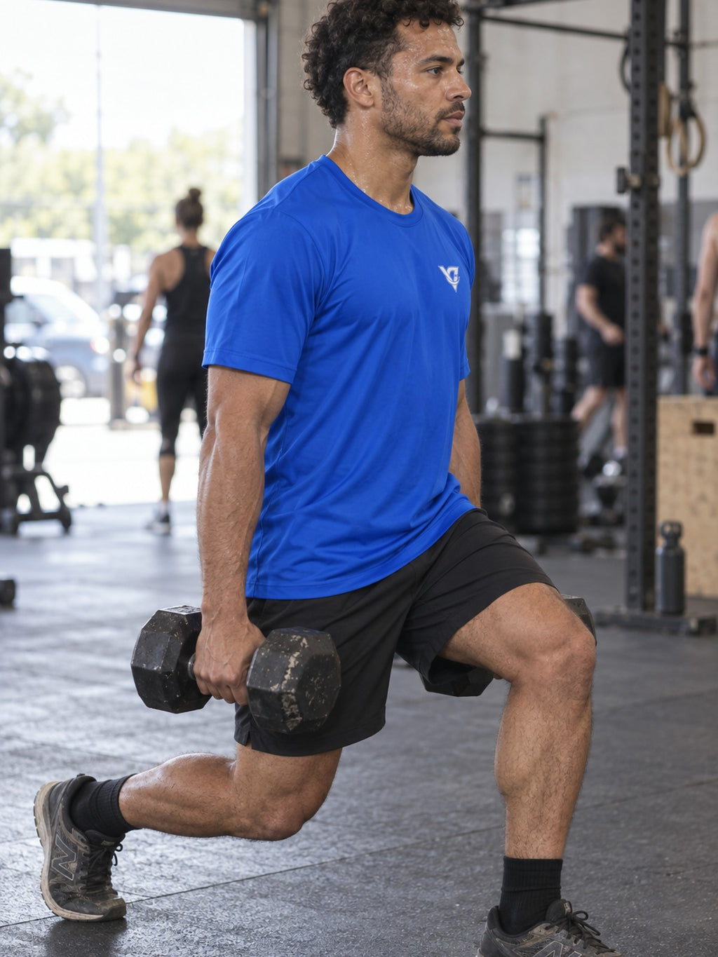 Man training in the Royal Blue Essential men's sports jersey with the Vantacore V emblem on the left chest – side view