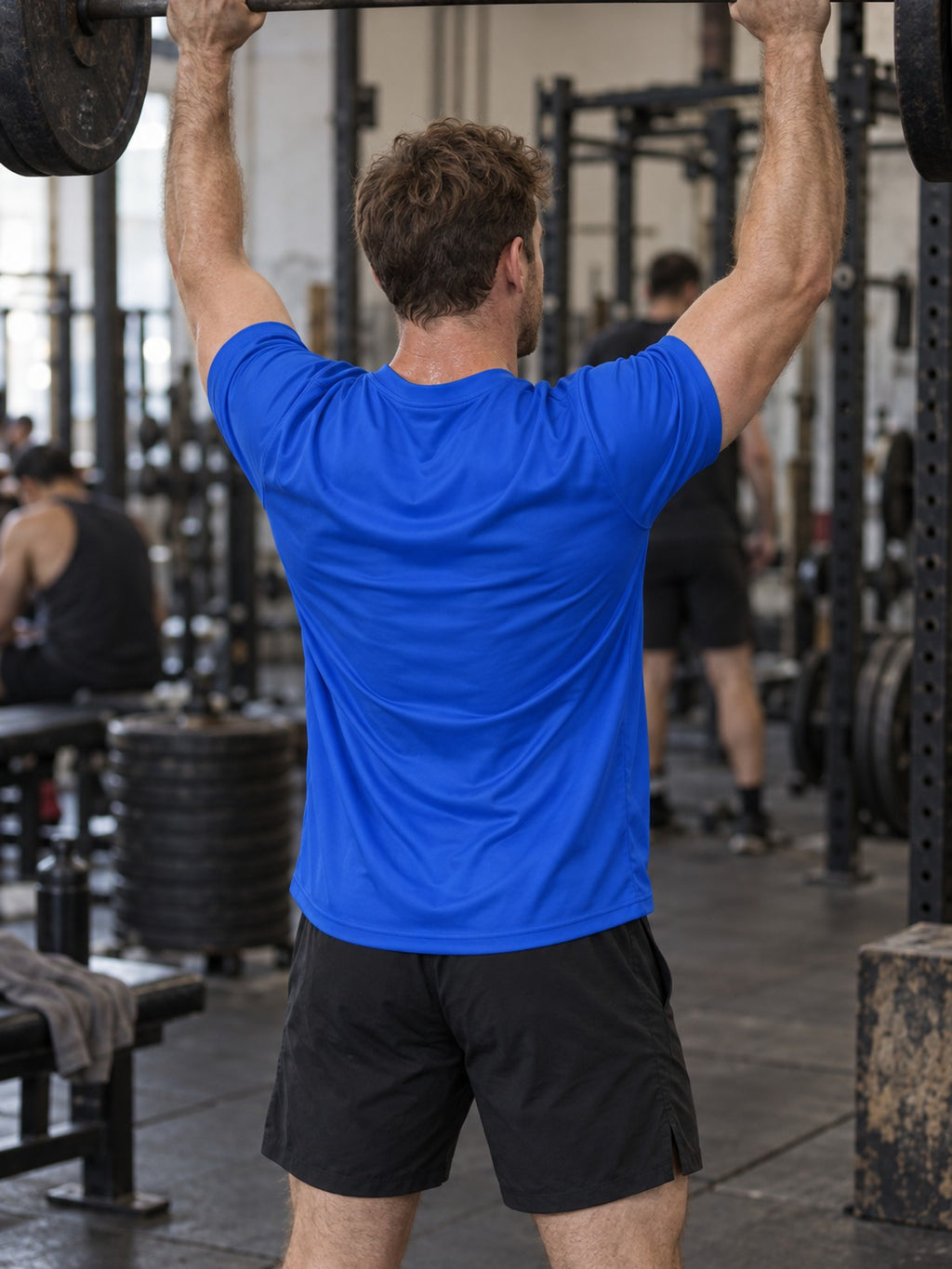 Man training in the Royal Blue Essential men's sports jersey with the Vantacore V emblem on the left chest – back view