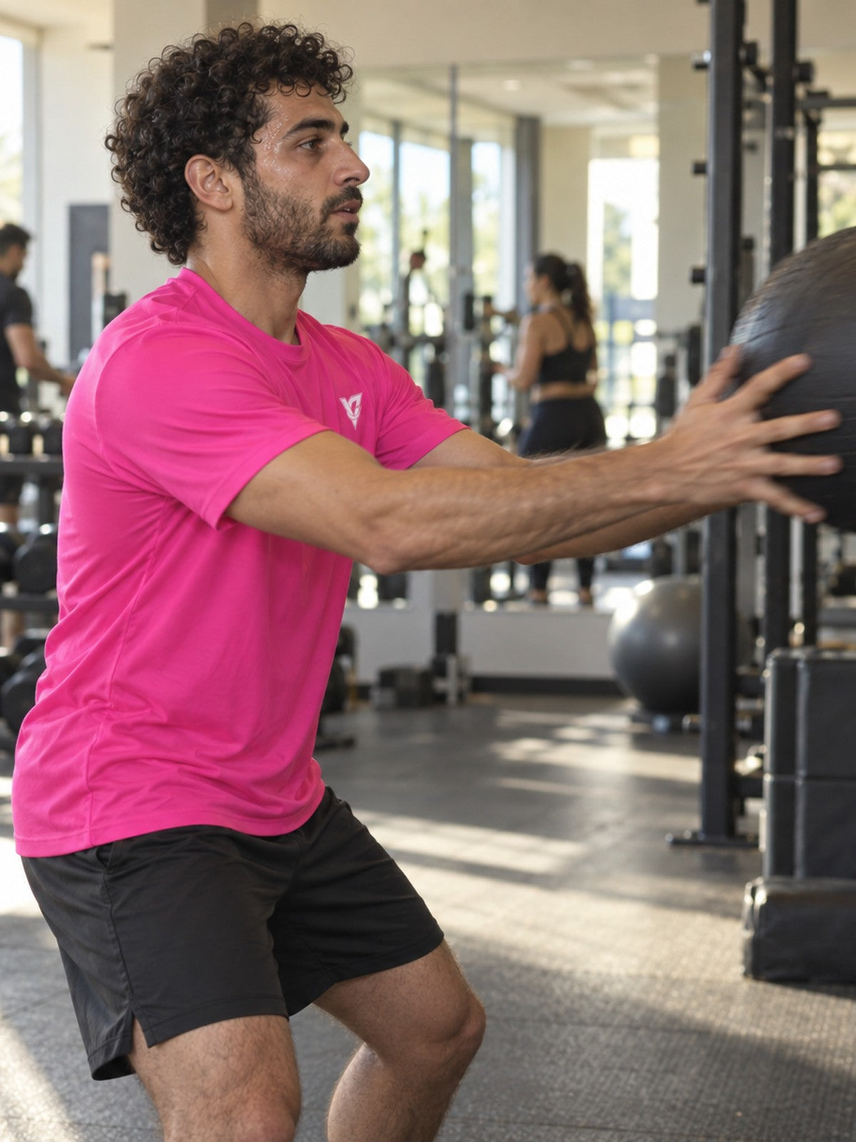 Man training in the Electric Pink Essential men's sports jersey with the Vantacore V emblem on the left chest – side view