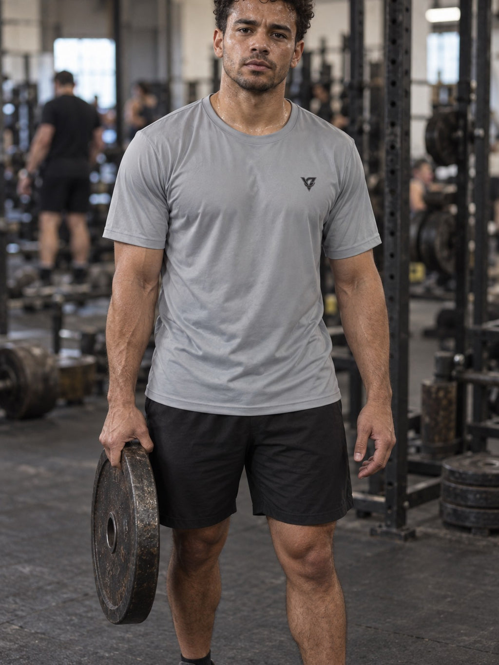 Man training in the Stone Grey Essential men's sports jersey with the Vantacore V emblem on the left chest – front view
