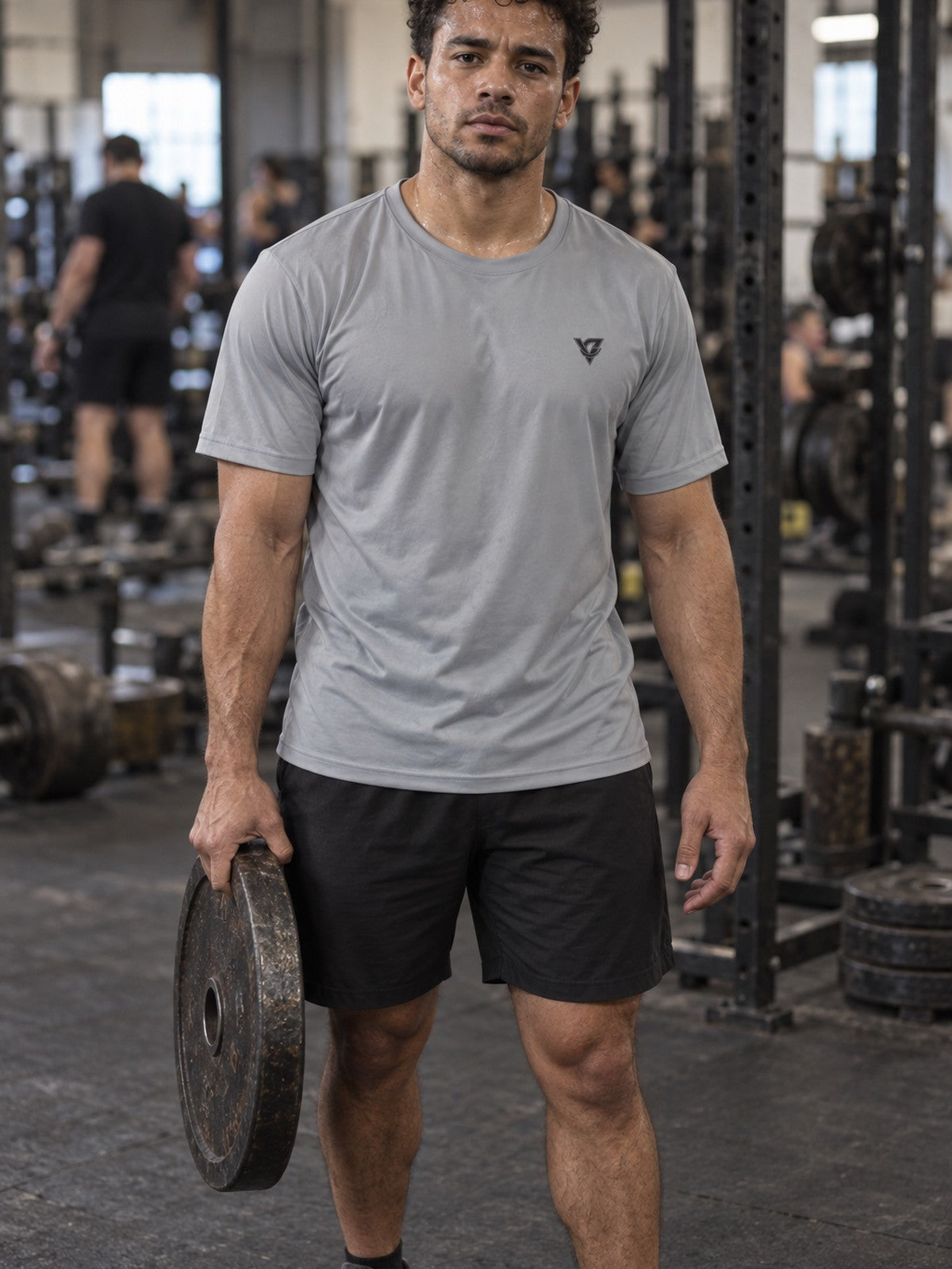 Man training in the Stone Grey Essential men's sports jersey with the Vantacore V emblem on the left chest – front view