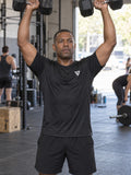 Man training in the Stealth Black Essential men's sports jersey with the Vantacore V emblem on the left chest – front view
