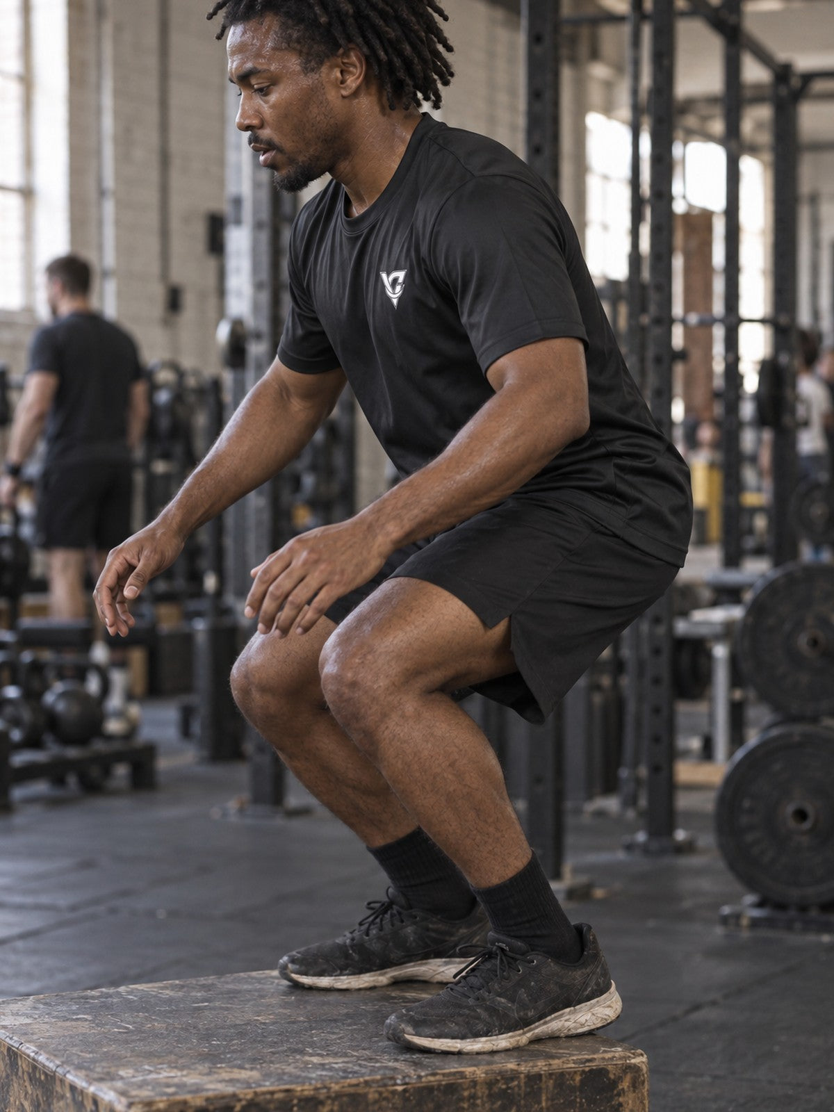 Man training in the Stealth Black Essential men's sports jersey with the Vantacore V emblem on the left chest – side view