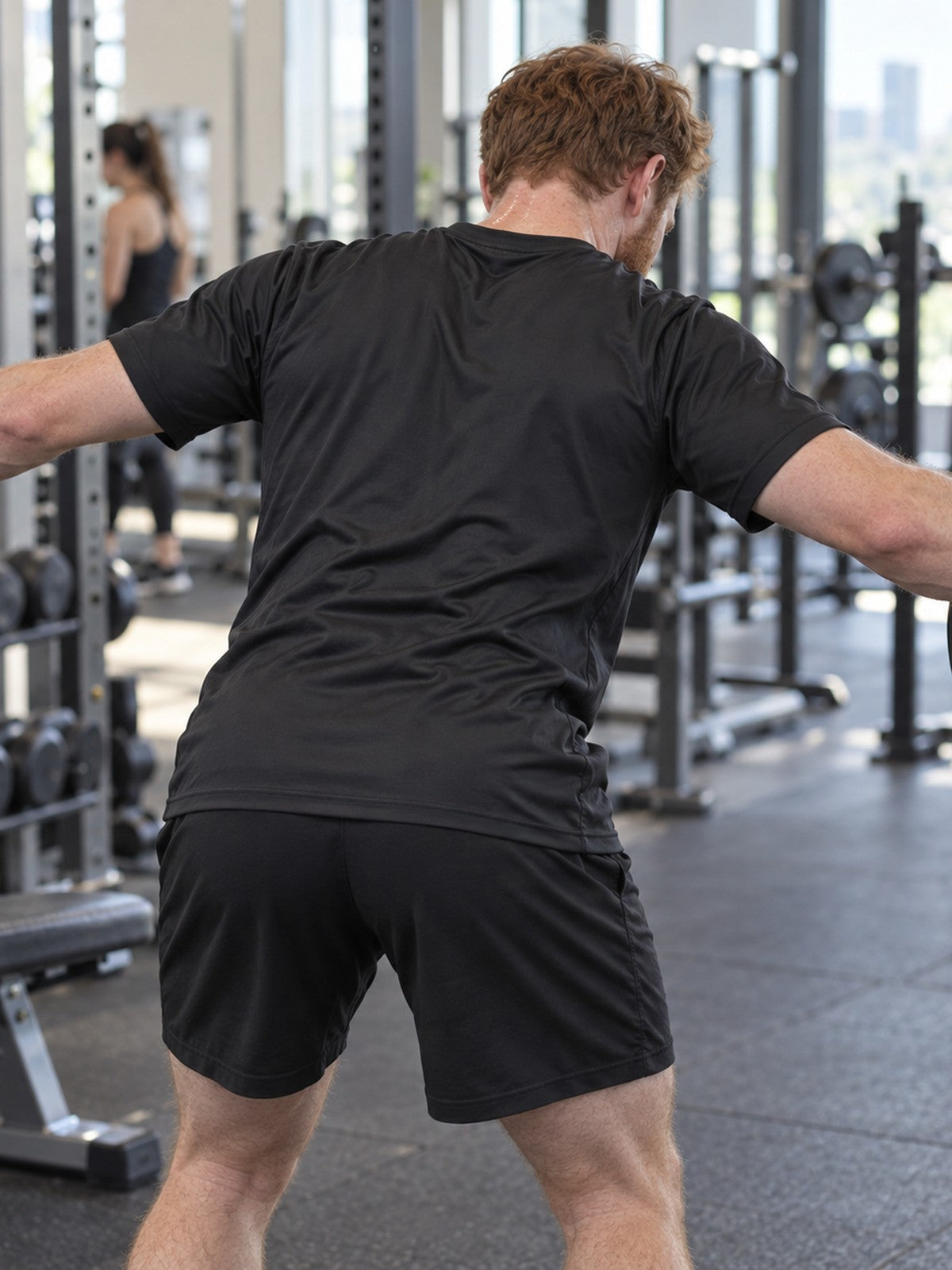 Man training in the Stealth Black Essential men's sports jersey with the Vantacore V emblem on the left chest – back view