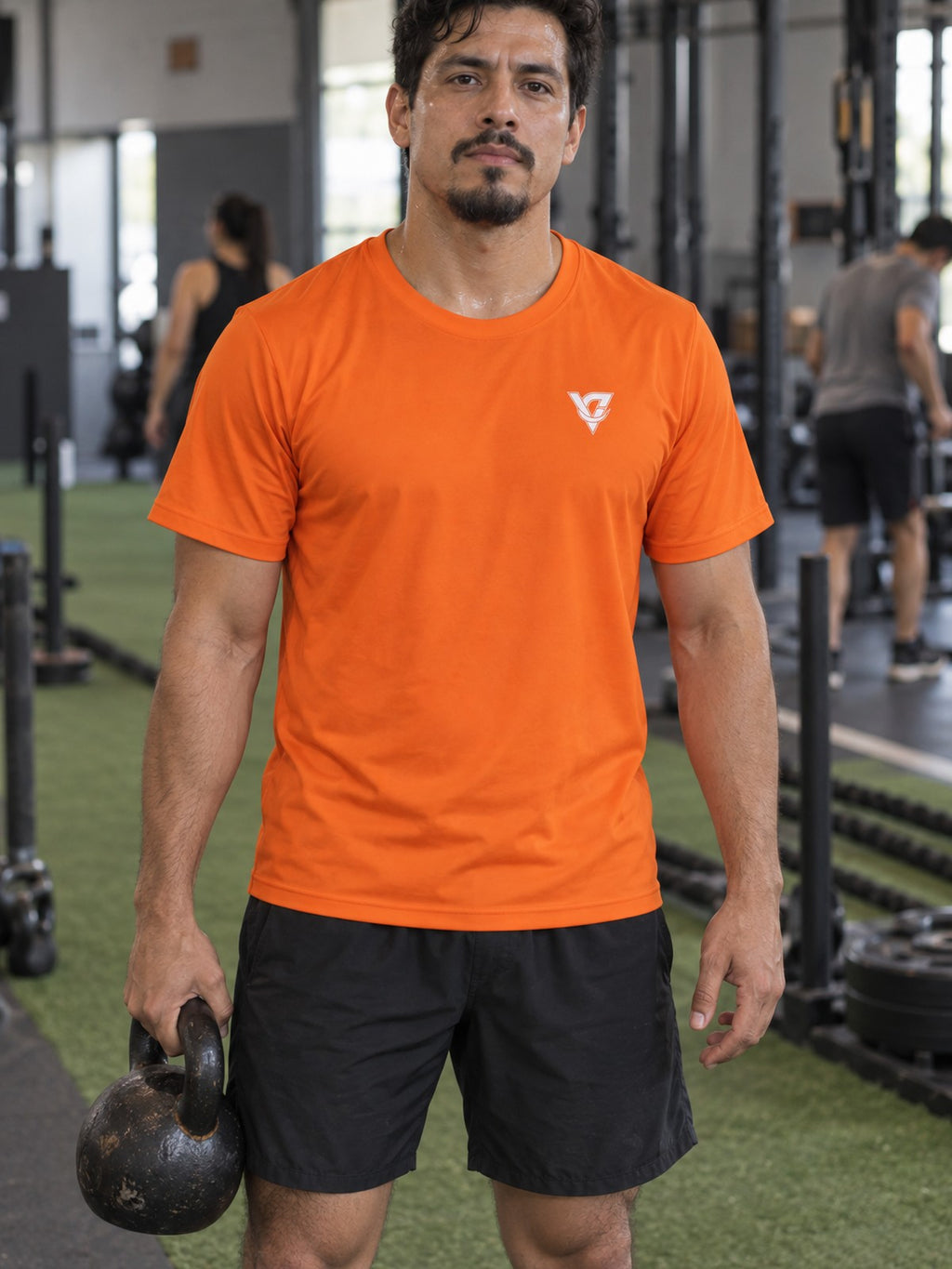 Man training in the Blaze Orange Essential men's sports jersey with the Vantacore V emblem on the left chest – front view