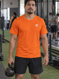 Man training in the Blaze Orange Essential men's sports jersey with the Vantacore V emblem on the left chest – front view