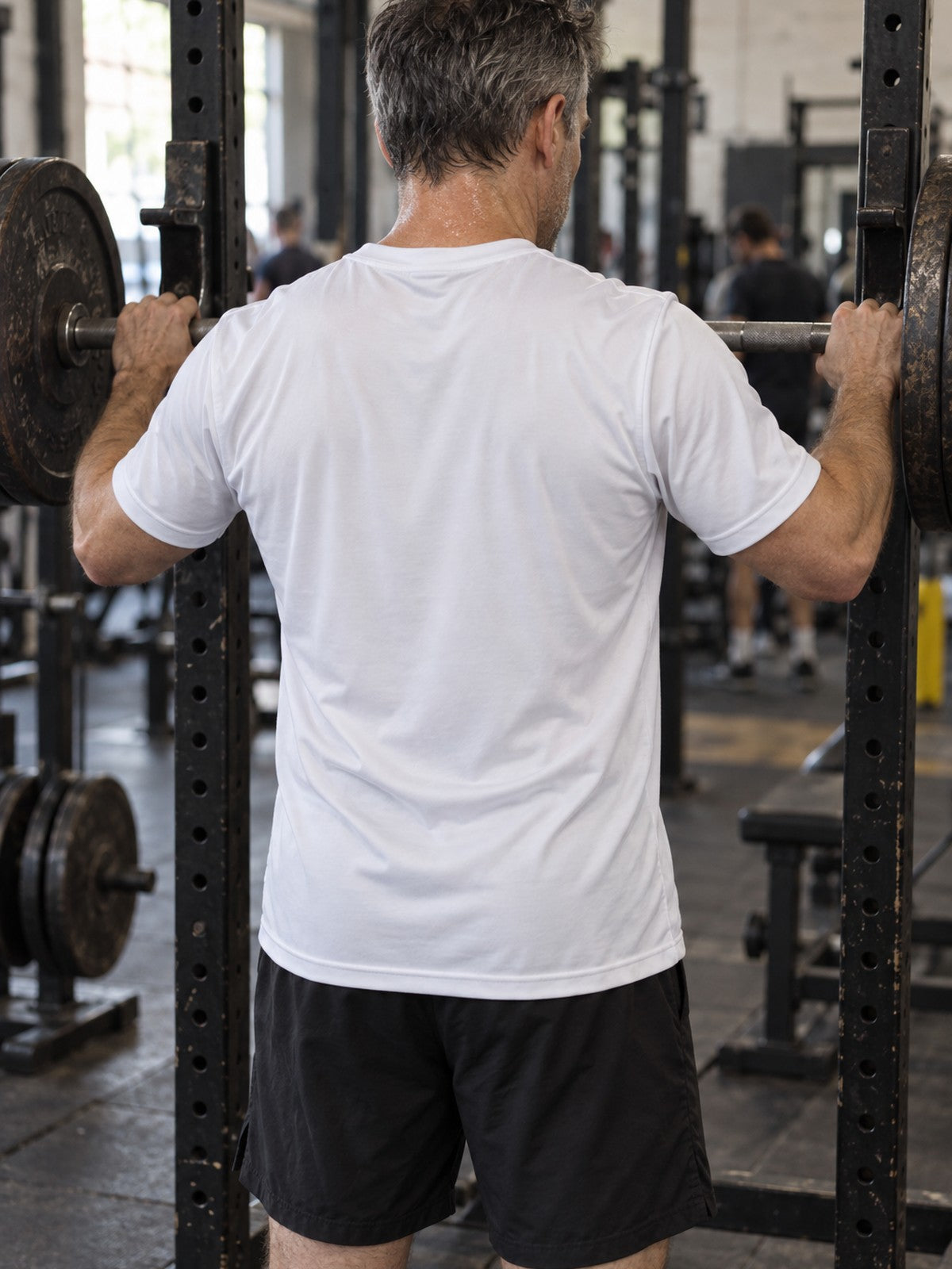 Man training in the Arctic White Essential men's sports jersey with the Vantacore V emblem on the left chest – back view