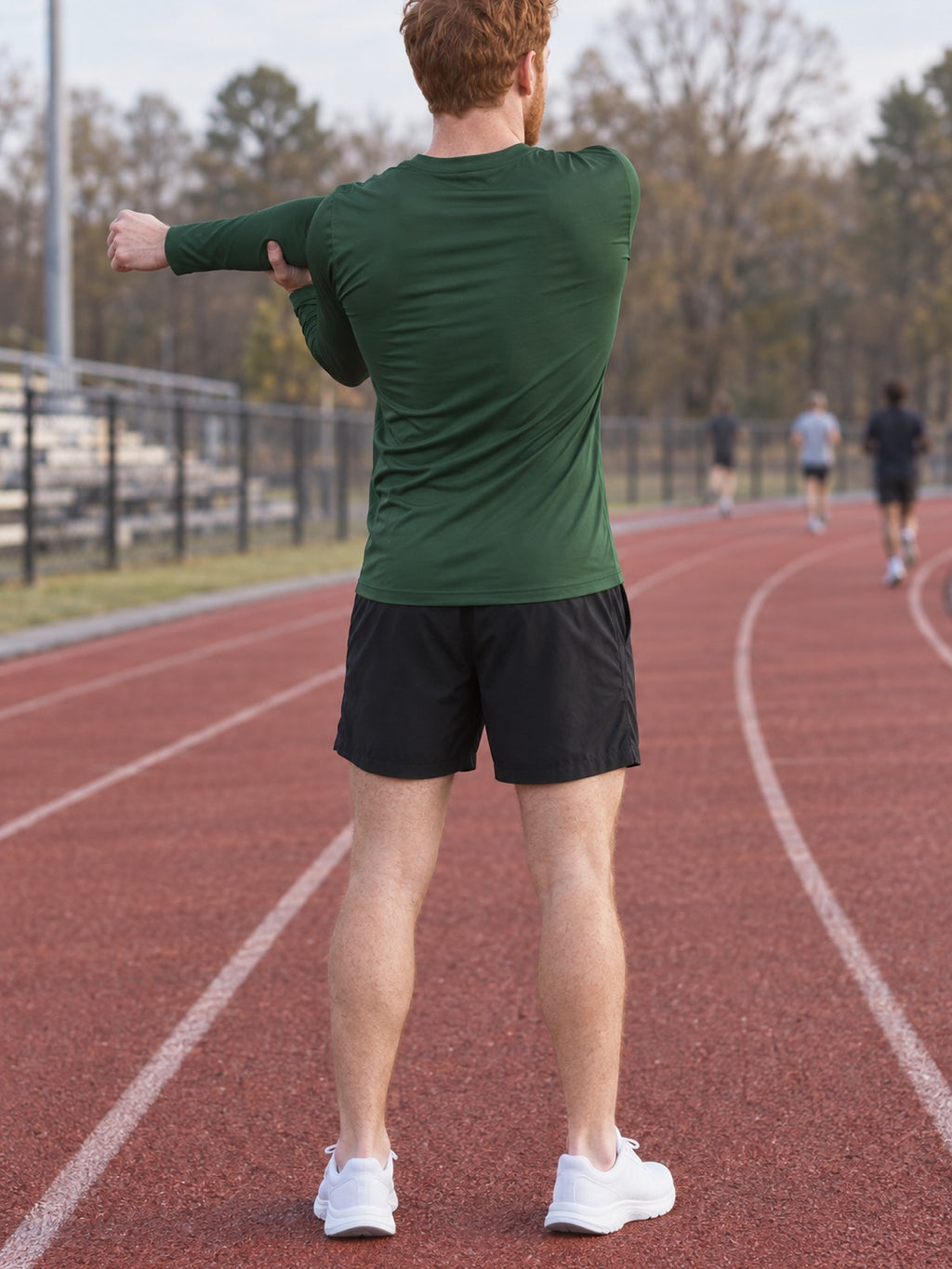 Man wearing the Forest Green Essential Men's Long Sleeve Athletic Shirt