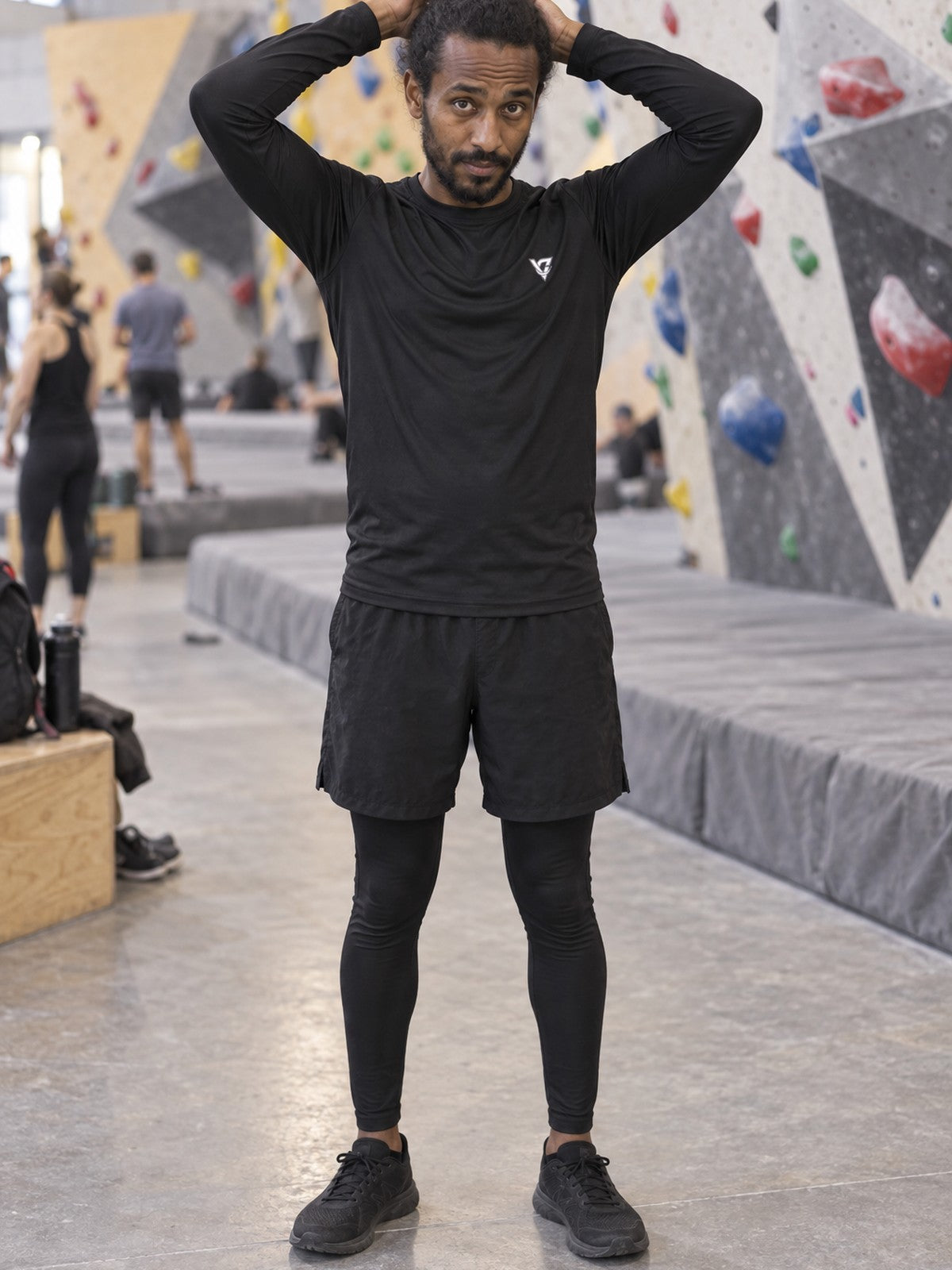 Man wearing the Stealth Black Essential Men's Long Sleeve Athletic Shirt