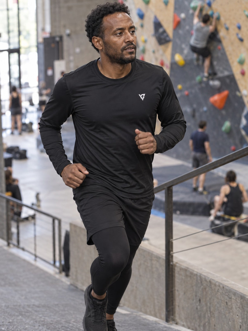 Man wearing the Stealth Black Essential Men's Long Sleeve Athletic Shirt