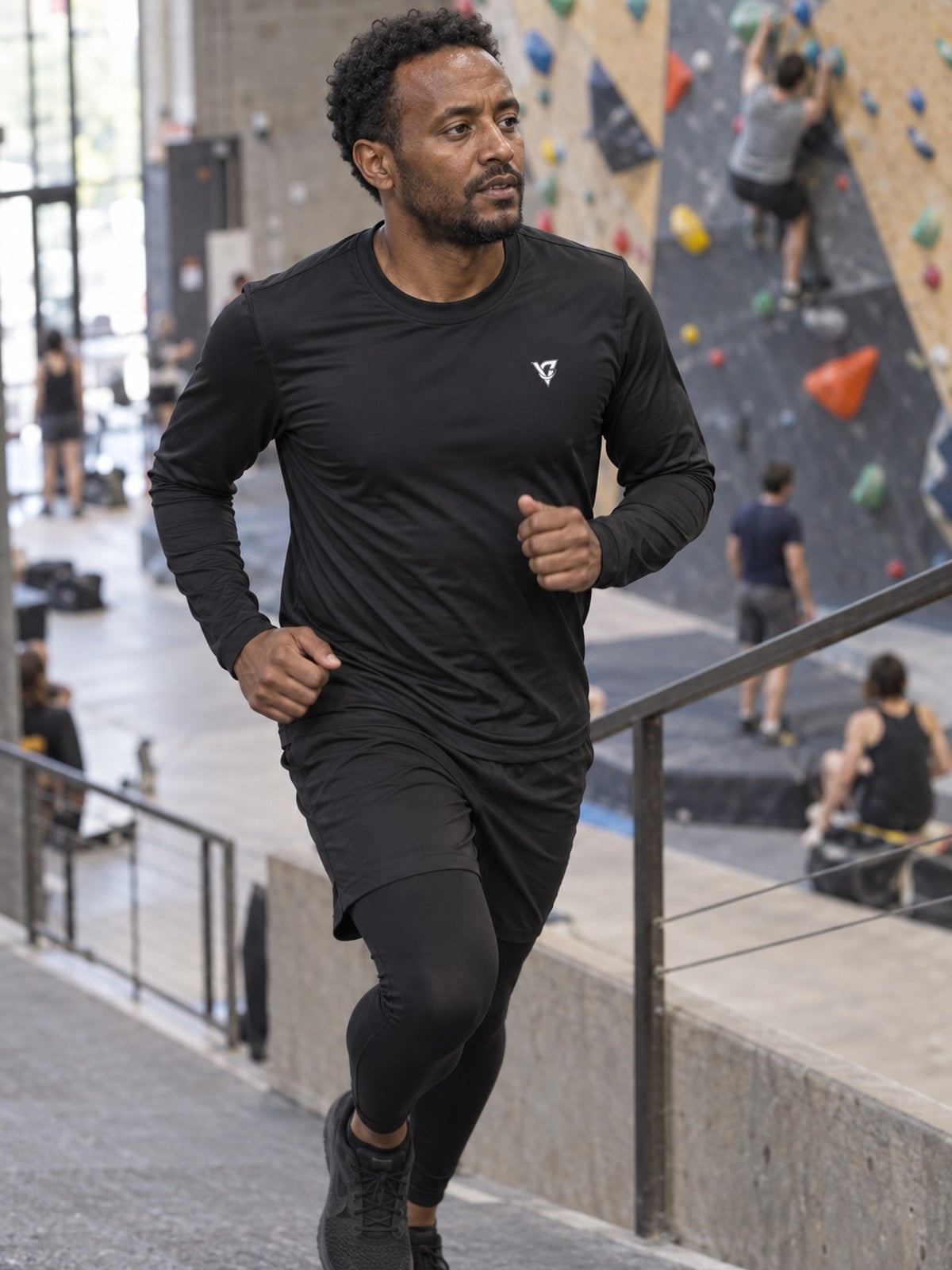 Man wearing the Stealth Black Essential Men's Long Sleeve Athletic Shirt
