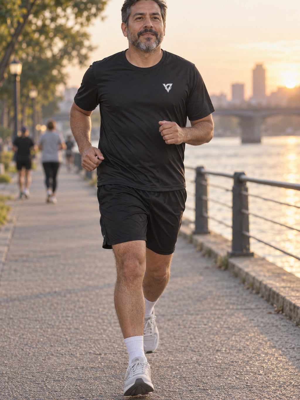 Man wearing the Stealth Black Essential men's matching set – athletic shirt and multipurpose shorts – front view