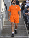 Man wearing the Blaze Orange Essential men's matching set – athletic shirt and multipurpose shorts – front view