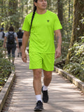 Man wearing the Volt Green Essential men's matching set – athletic shirt and multipurpose shorts – front view