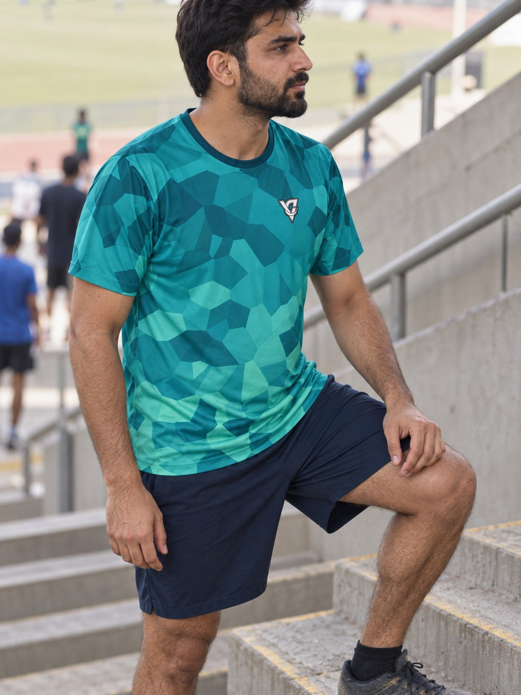 Man training in the Teal Shard men's sports jersey with the Vantacore V emblem on the left chest – side view