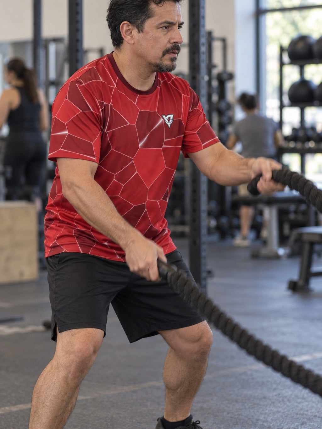 Man training in the Crimson Shatter men's sports jersey with the Vantacore V emblem on the left chest – side view