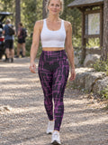 Woman wearing the Magenta Circuit high-waisted yoga leggings with the Vantacore V emblem on the hip – front view