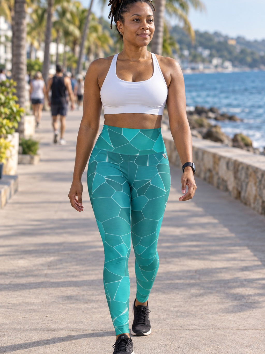 Woman wearing the Turquoise Shatter high-waisted yoga leggings with the Vantacore V emblem on the hip – front view